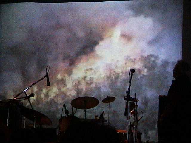 Band equipment silhouetted against Roger's video at the presentation to the Fire Brigade