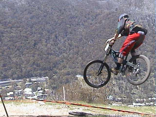 Mountain biker getting airtime above the village