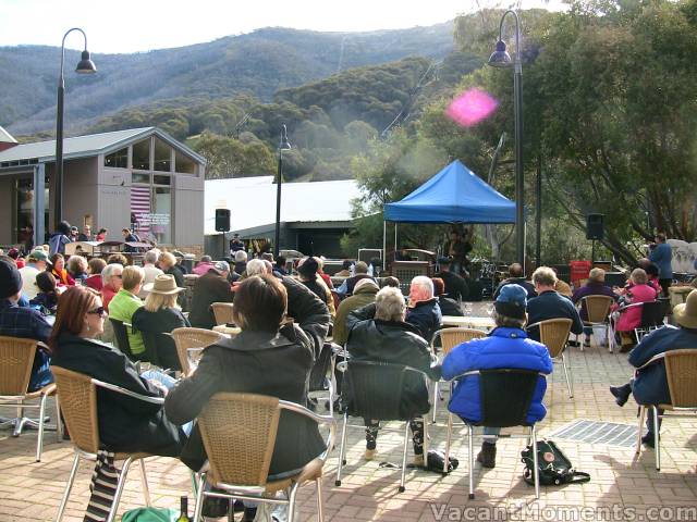 Large crowd in the Village Square enjoying sun and jazz