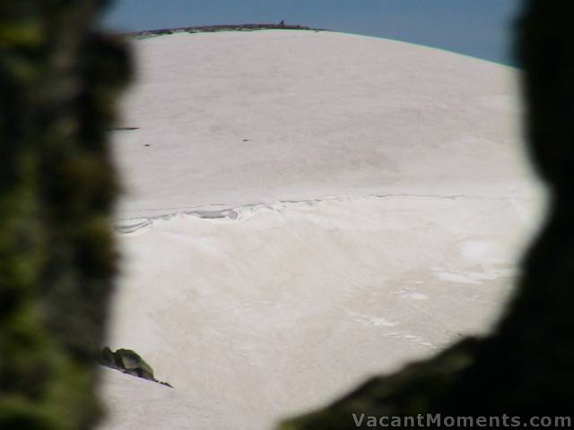 View of Mt Kosciuszko through a crack in the rocks at the top of Everest