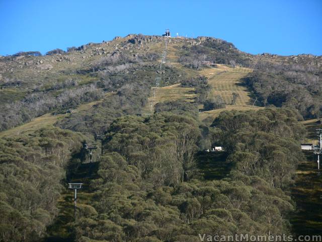 Groomed slopes under a blue sky