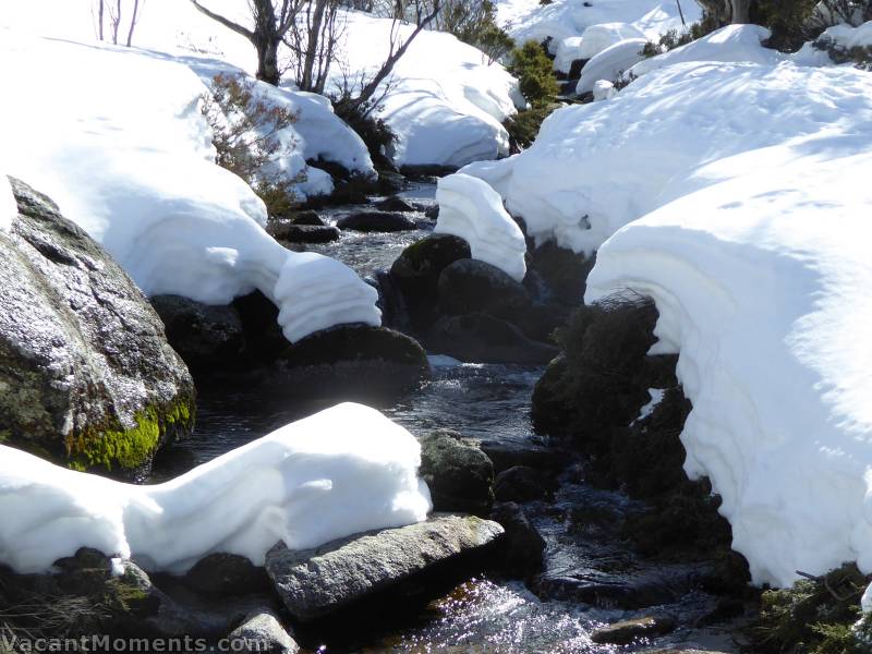 It appears that a sudden rise in water level has carved away the snow pack since my last visit