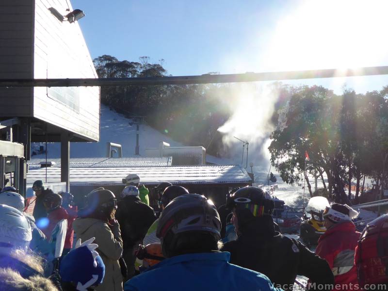 Sunday first-lift queue whilst snow guns blast away in the background