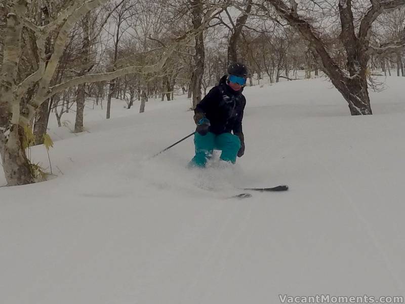 Andrea in the trees, off the board and back on her skis